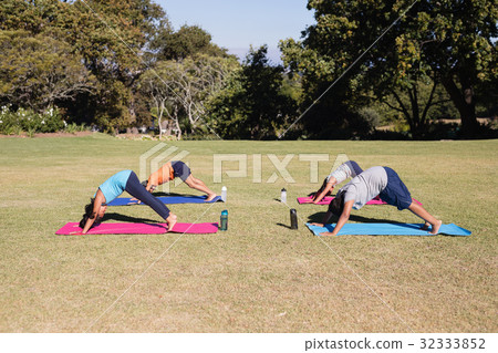 Side view of kids practicing downward facing dog pose 32333852