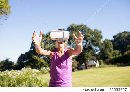 Girl using vr headset in the park Girl using vr headset in the park 32333857