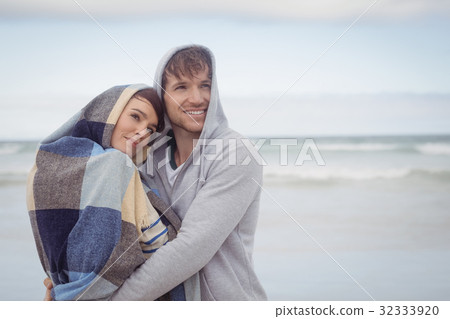 Thoughtful youn couple embracing during winter Thoughtful youn couple embracing during winter 32333920