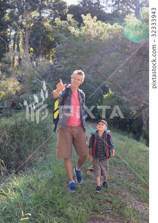 Happy father pointing while hiking with son Happy father pointing while hiking with son 32333943