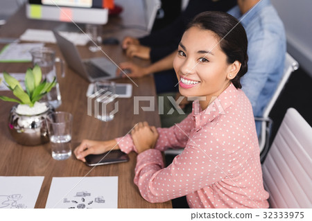 Portrait of businesswoman sitting at desk 32333975