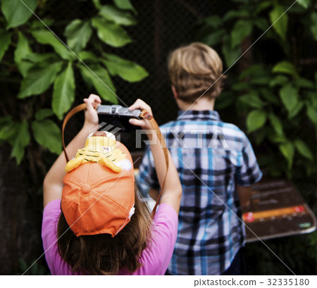 Rear view of young caucasian girl taking photo with camera Rear view of young caucasian girl taking photo with camera 32335180