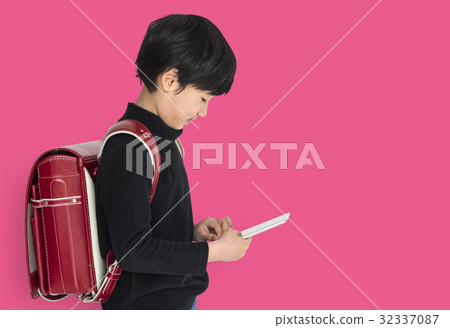 Young asian kid with a backpack using a tablet isolated portrait Young asian kid with a backpack using a tablet isolated portrait 32337087