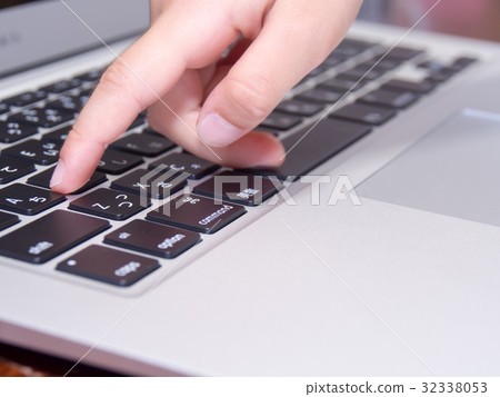 A hand of a child operating a personal computer 32338053