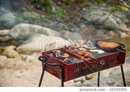 Barbecue at the waterside Char-grilled meat roasted with thick sausages Barbecue at the waterside Char-grilled meat roasted with thick sausages 32345008