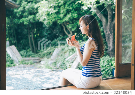 A woman eating watermelon at the edge 32348084
