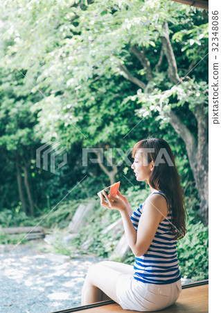 A woman eating watermelon at the edge 32348086