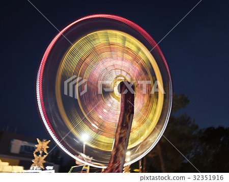 Illuminated rotating carousel in the evening park 32351916