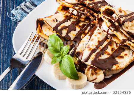 Crepes with banana and chocolate cream Crepes with banana and chocolate cream 32354526