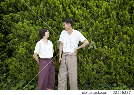 一對夫婦帶著微笑穿著放鬆穿綠色背 一對夫婦帶著微笑穿著放鬆穿綠色背 32356227