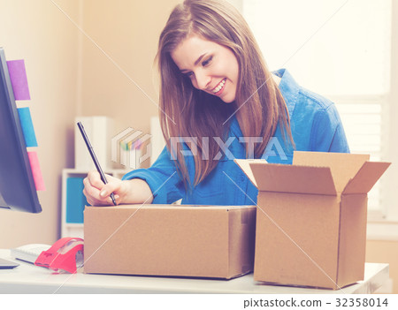 Young woman packing boxes to be shipped Young woman packing boxes to be shipped 32358014