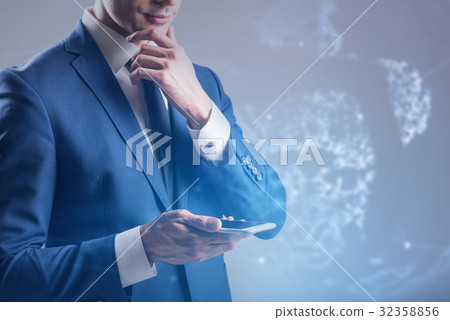 Pensive young man is using modern mobile phone 32358856