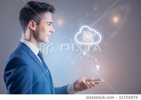 Pleasant businessman is holding mobile phone 32358859