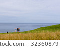 Boy sitting on te edge of a scarp, above the sea 32360879