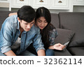 Happy couple online shopping at home 32362114