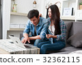 Happy couple online shopping at home 32362115