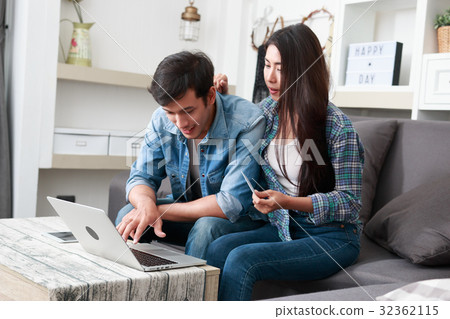 Happy couple online shopping at home 32362115