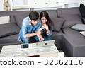 Happy couple online shopping at home 32362116