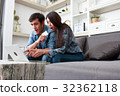 Happy couple online shopping at home 32362118