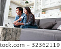 Happy couple online shopping at home 32362119