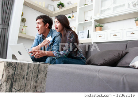 Happy couple online shopping at home 32362119