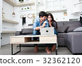 Happy couple online shopping at home 32362120