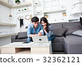 Happy couple online shopping at home 32362121