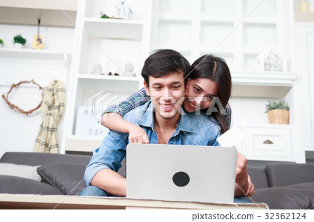 Happy couple online shopping at home Happy couple online shopping at home 32362124