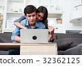 Happy couple online shopping at home 32362125