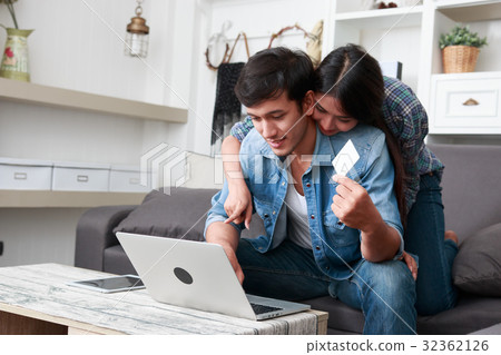 Happy couple online shopping at home 32362126