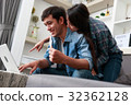 Happy couple online shopping at home 32362128