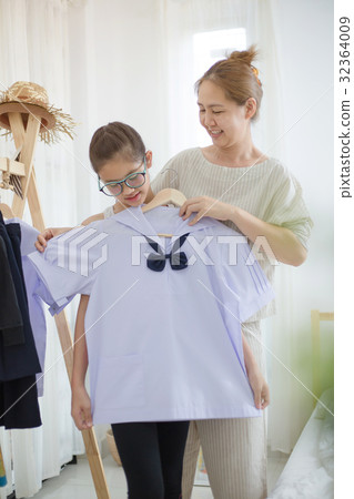 Asian mother helping daughter dressing uniform 32364009