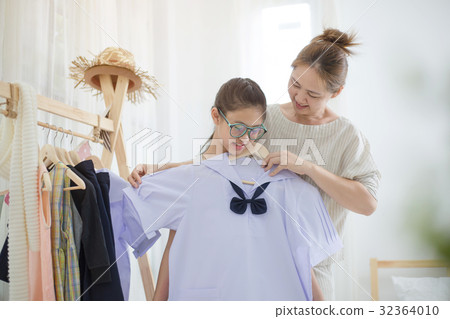 Asian mother helping daughter dressing uniform 32364010