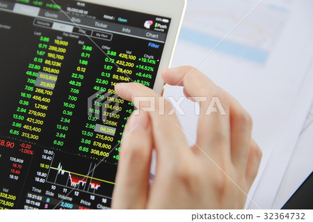 Woman hand Trading online on tablet with business paper and coffee Woman hand Trading online on tablet with business paper and coffee 32364732
