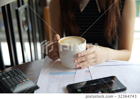 A business woman hand with coffee and business paper A business woman hand with coffee and business paper 32364743