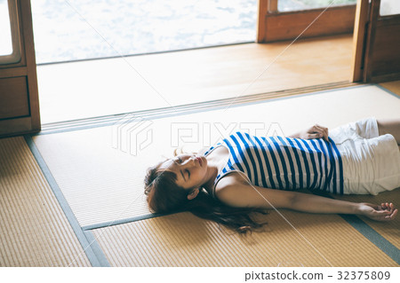A woman taking a nap in a Japanese style room 32375809