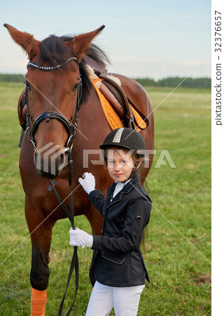 Little girl lead horse by its reins 32376657