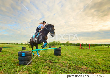 Young girl jockey and her horse jumper Young girl jockey and her horse jumper 32376695