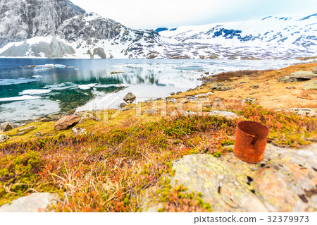 Old rusty can on lake shore. Earth ecology 32379973