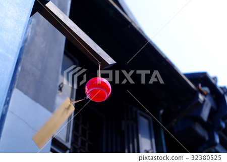 A wind chime looking up One red black warehouse eaves background blur A wind chime looking up One red black warehouse eaves background blur 32380525
