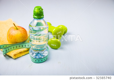 Dumbbells, an apple, a towel and a bottle of water Dumbbells, an apple, a towel and a bottle of water 32385740