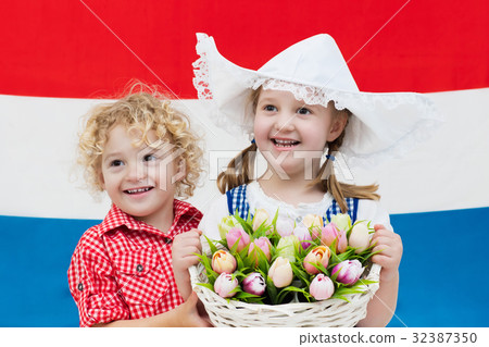 Dutch kids with tulip flowers and Netherlands flag Dutch kids with tulip flowers and Netherlands flag 32387350