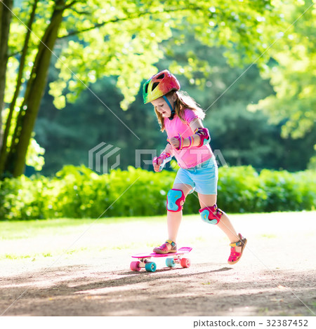Child riding skateboard in summer park 32387452