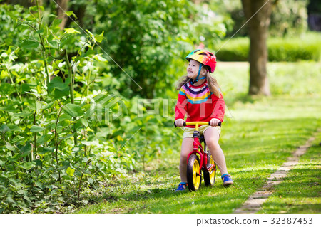 Kids ride balance bike in park 32387453