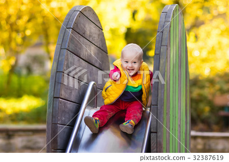 Child on playground in autumn. Kids in fall. Child on playground in autumn. Kids in fall. 32387619