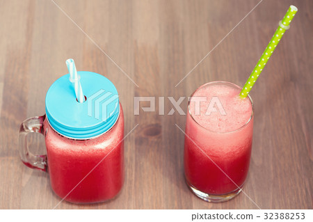 Watermelon smoothie in a mason jar and a glass 32388253