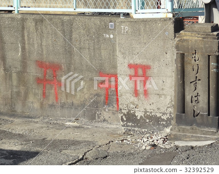 A torii drawn with a spray can on the embankment of a river A torii drawn with a spray can on the embankment of a river 32392529