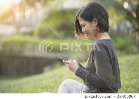 Women sitting on park and reading message chat 32400867