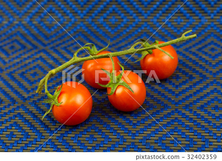 Juicy tomatoes on a green branch against Juicy tomatoes on a green branch against 32402359