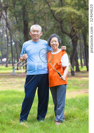 smiling senior couple holding badminton racket  32404620
